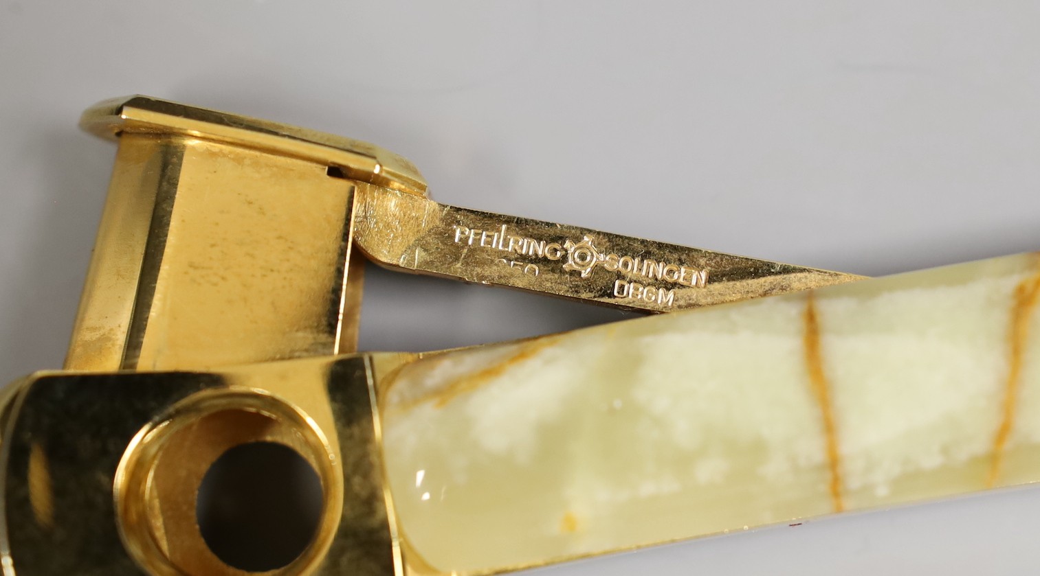 An onyx and gilt-metal cigar cutter, a smaller plated cheroot cutter and a cased 9ct mounted cheroot holder